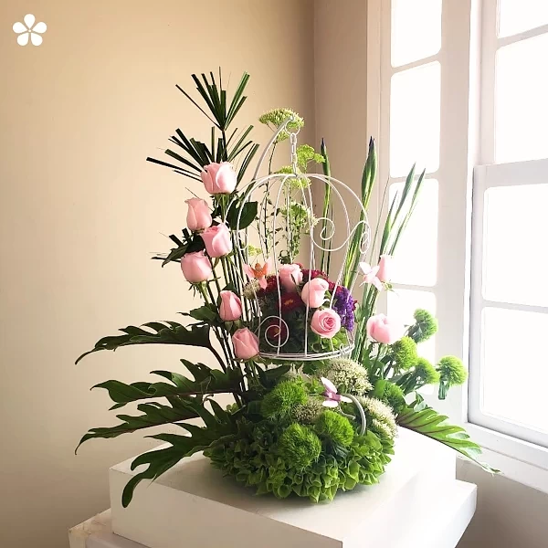 Colibríes en vuelo - jaula floral con rosas y eucalipto